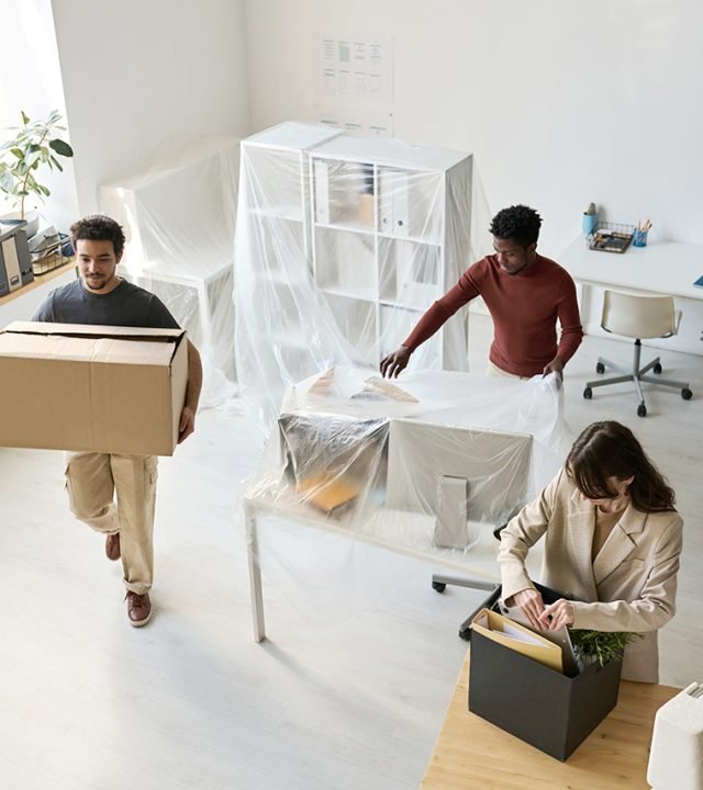 High angle view of business people packing things and furniture while moving in new office